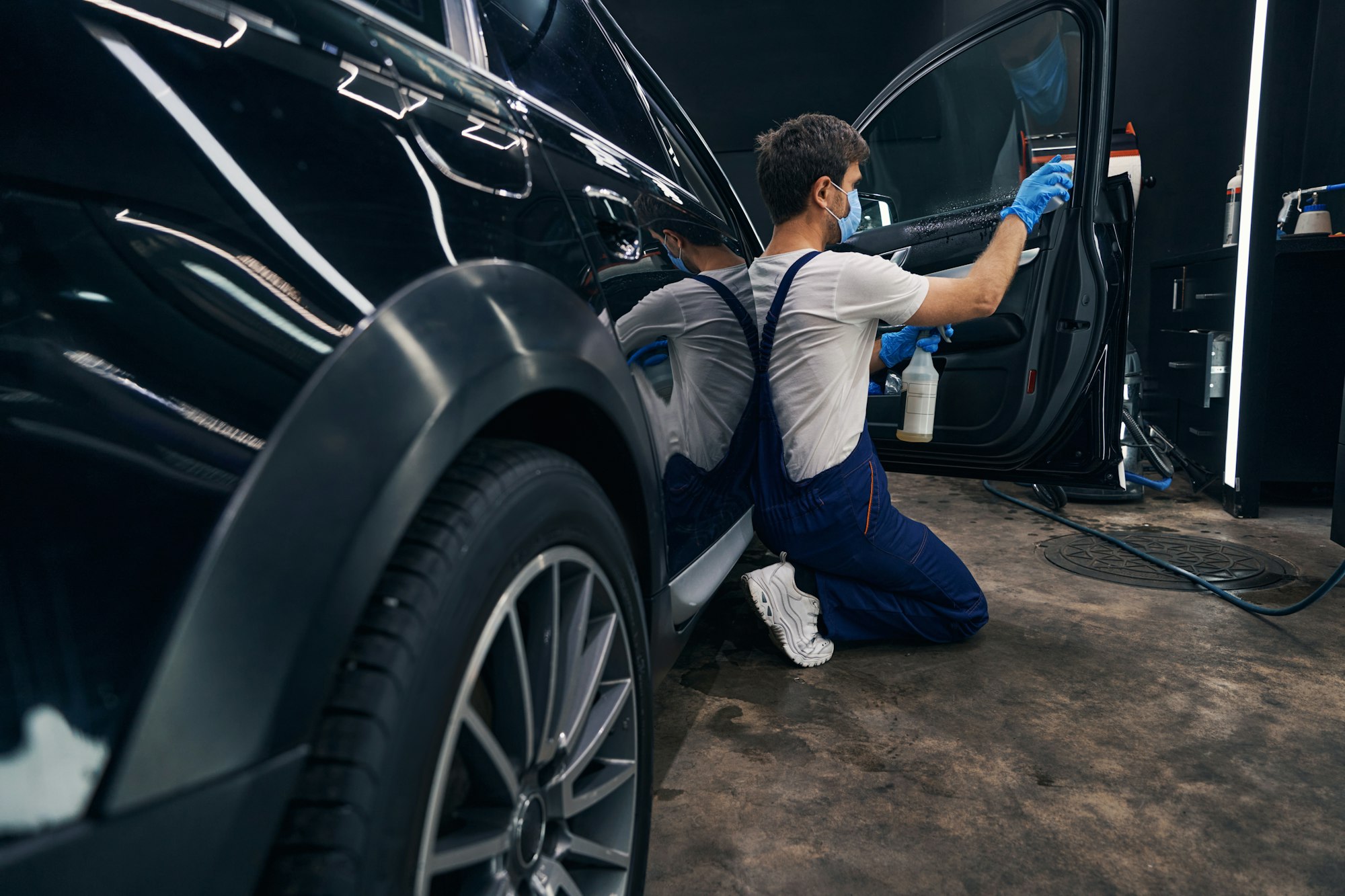 man-in-repair-workshop-washing-car-window-during-car-valeting.jpg